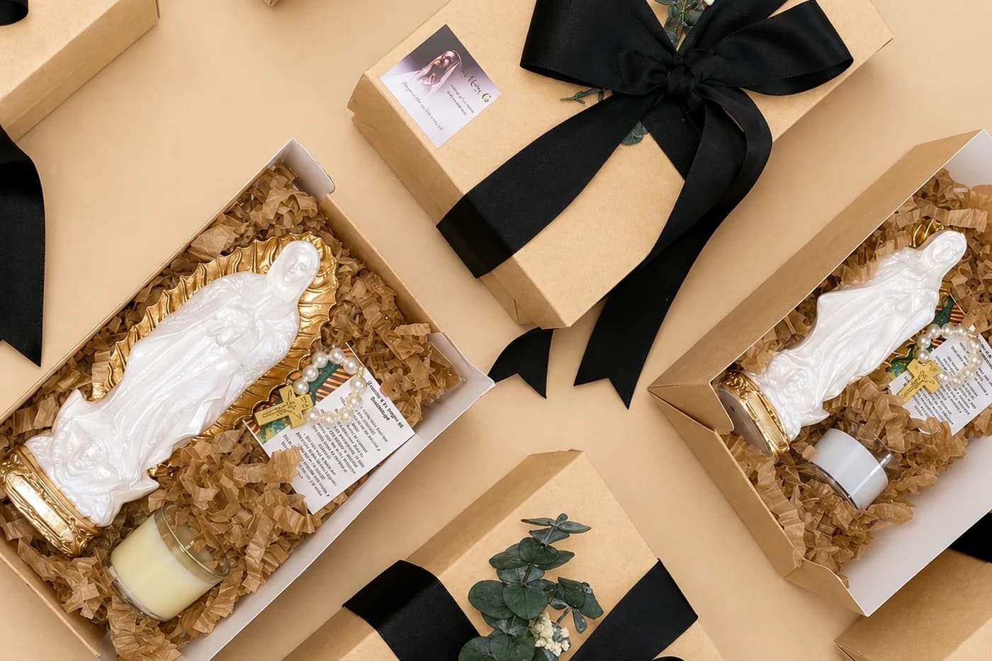 Cajas de regalo abiertas con figuras, velas y ramas de eucalipto